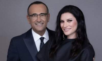 Carlo Conti e Laura Pausini sorridenti durante l'annuncio della conduzione di Sanremo 2026.
