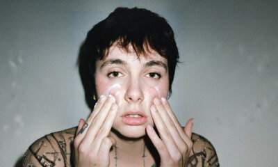 Madame (Francesca Calearo) in una foto promozionale dell'album Disincanto, con le mani sul viso e tatuaggi visibili