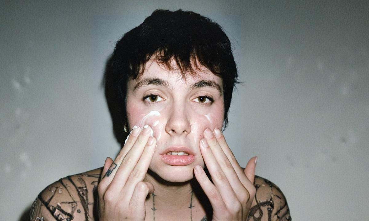 Madame (Francesca Calearo) in una foto promozionale dell'album Disincanto, con le mani sul viso e tatuaggi visibili