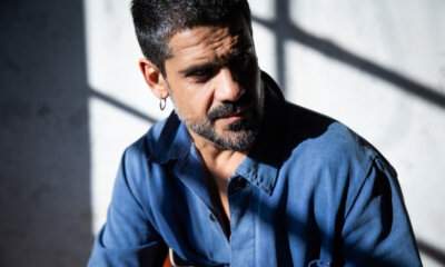 Primo piano del cantautore Mannarino illuminato da un taglio di luce, scatto di Chiara Mirelli.