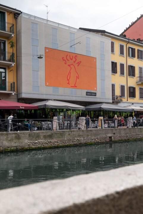 Cartellone con pinguino e scritta Scusa sui Navigli a Milano per il possibile nuovo singolo dei Pinguini Tattici Nucleari