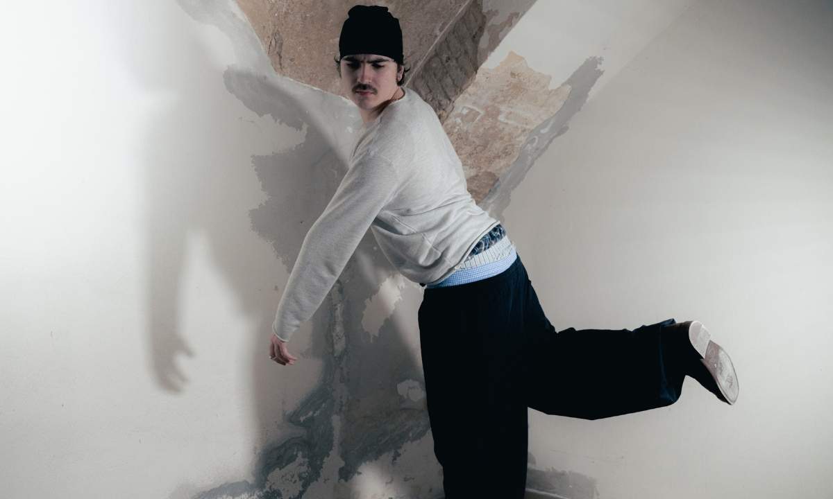 Umarell in posa contro un muro scrostato con berretto nero e felpa grigia, scatto promozionale del quarto album "1000%"