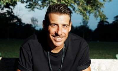 Francesco Gabbani in foto promo del singolo Summer Funk, seduto su una panchina di parco con t-shirt nera e collane, sorridente, sfondo di alberi al tramonto