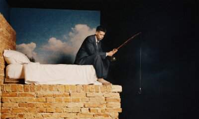 Leon Faun seduto sul bordo di un letto con una canna da pesca, foto promozionale del nuovo album Fase REM.