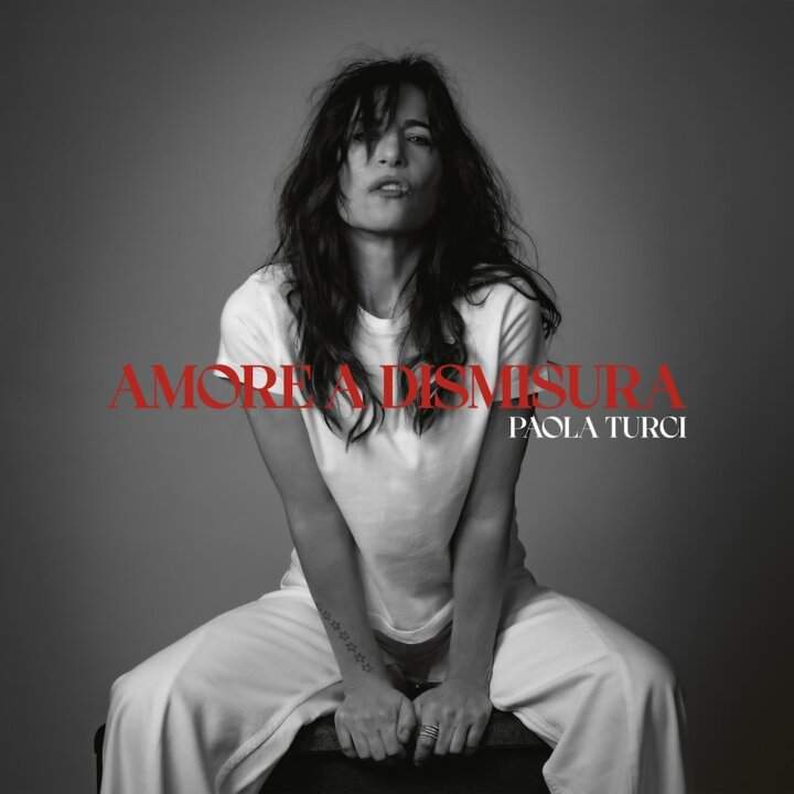 Cover of the album Amore a dismeasure by Paola Turci with the singer-songwriter sitting in the foreground and title in red