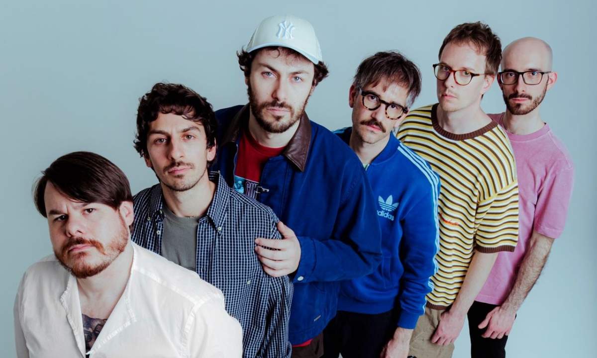I Pinguini Tattici Nucleari in foto promozionale del nuovo singolo Sorry Scusa Lo Siento, sei membri della band ritratti dall'alto su sfondo chiaro