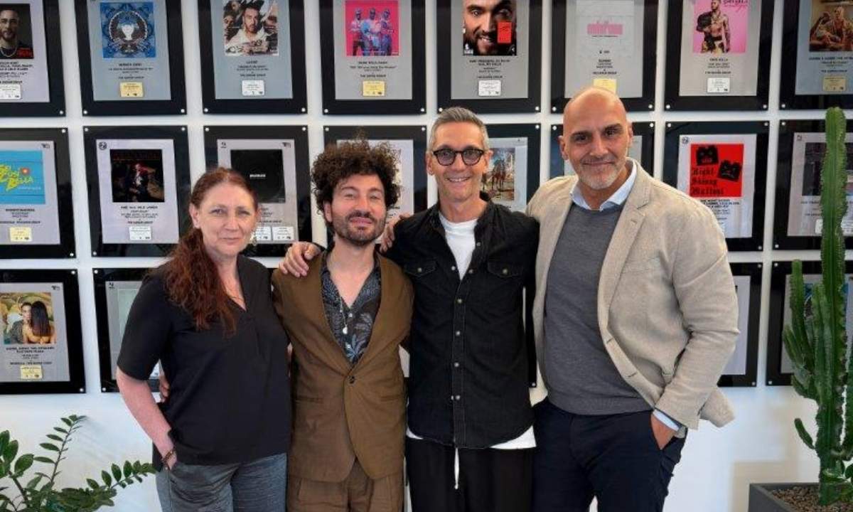 Da sinistra Cristina Zoccatelli, Gianni Testa, Simone Farina e Luigi Maria Brescia, foto dell'annuncio dell'ingresso di Testa in The Saifam Group, con alle spalle i dischi del catalogo del gruppo