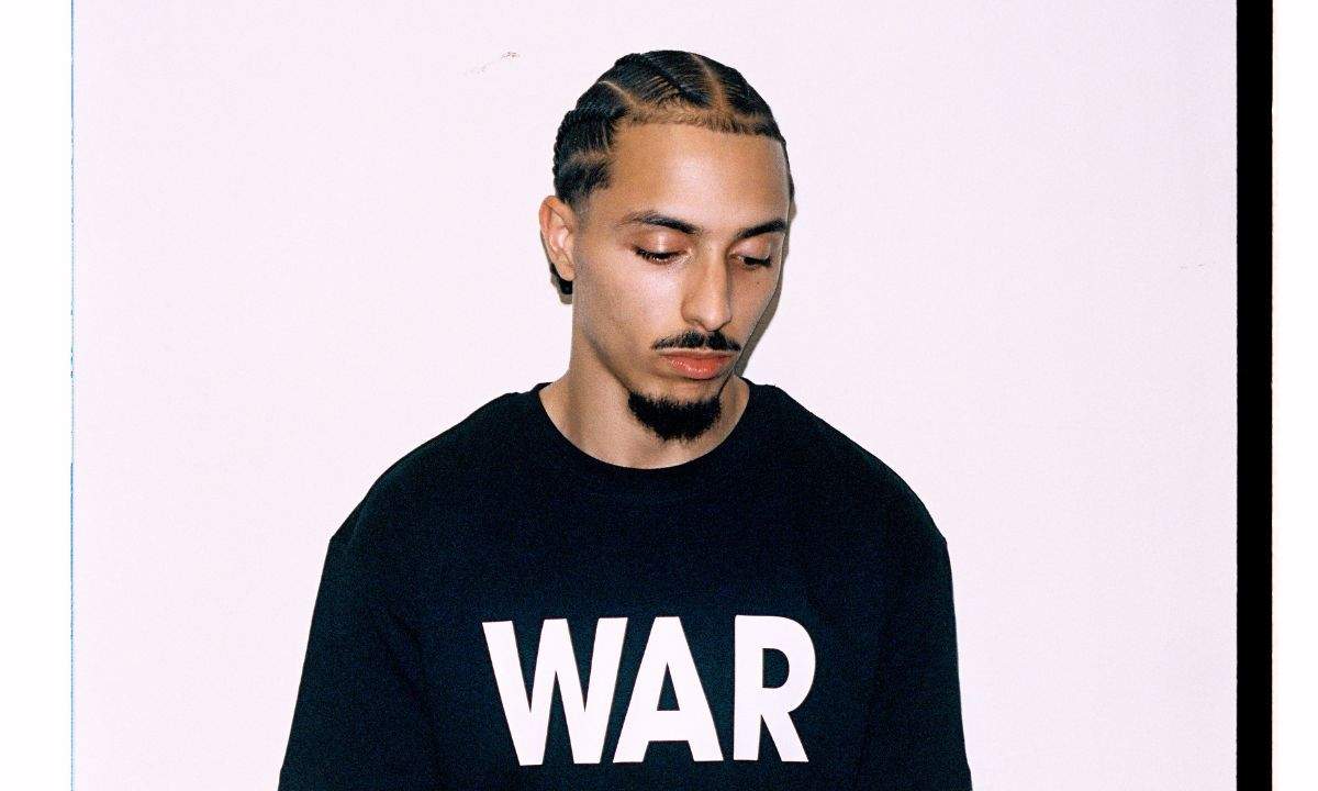 Astro con una felpa nera con la scritta WAR, ritratto promozionale del nuovo album