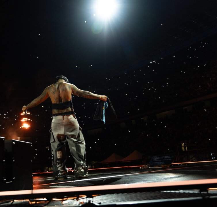 Geolier from behind in front of the San Siro audience during the concert