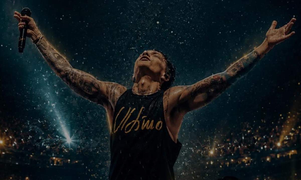 Ultimo a braccia aperte sul palco con il microfono in mano durante un concerto allo stadio