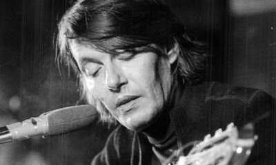 Fabrizio De André al microfono con la chitarra, foto in bianco e nero: Bocca di Rosa significato
