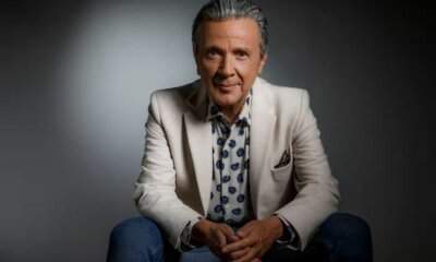 Pupo seduto con giacca bianca per il tour Su di noi... la nostra storia 2026-2027