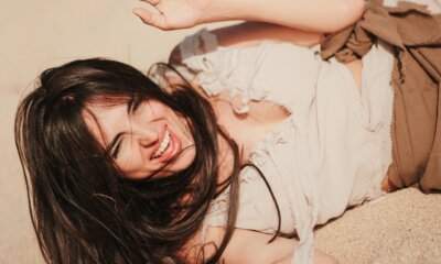 Ragazza sorridente sdraiata sulla sabbia: immagine del progetto DJ BIGZI e J€SS