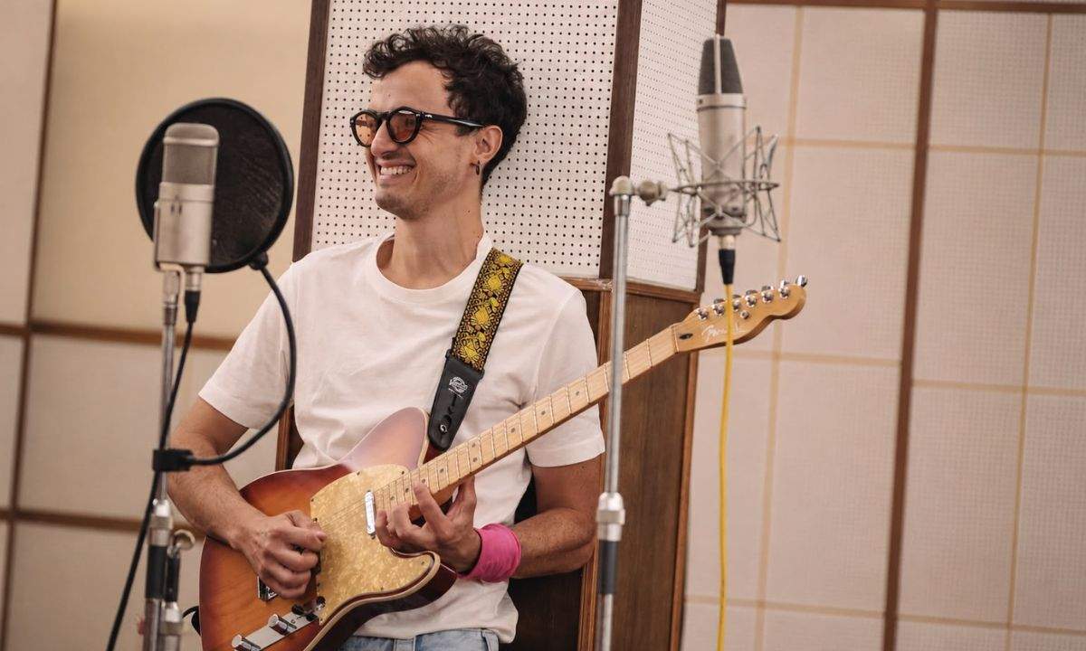 Folcast sorride con la chitarra in uno studio di registrazione