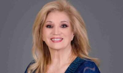 Iva Zanicchi sorride in primo piano con abito blu, ritratto del 2026