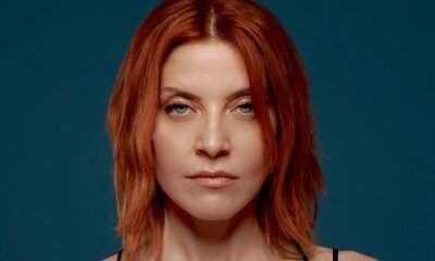 Noemi in primo piano su fondo blu: è prima nella classifica radio con Tu cosa fai questa sera