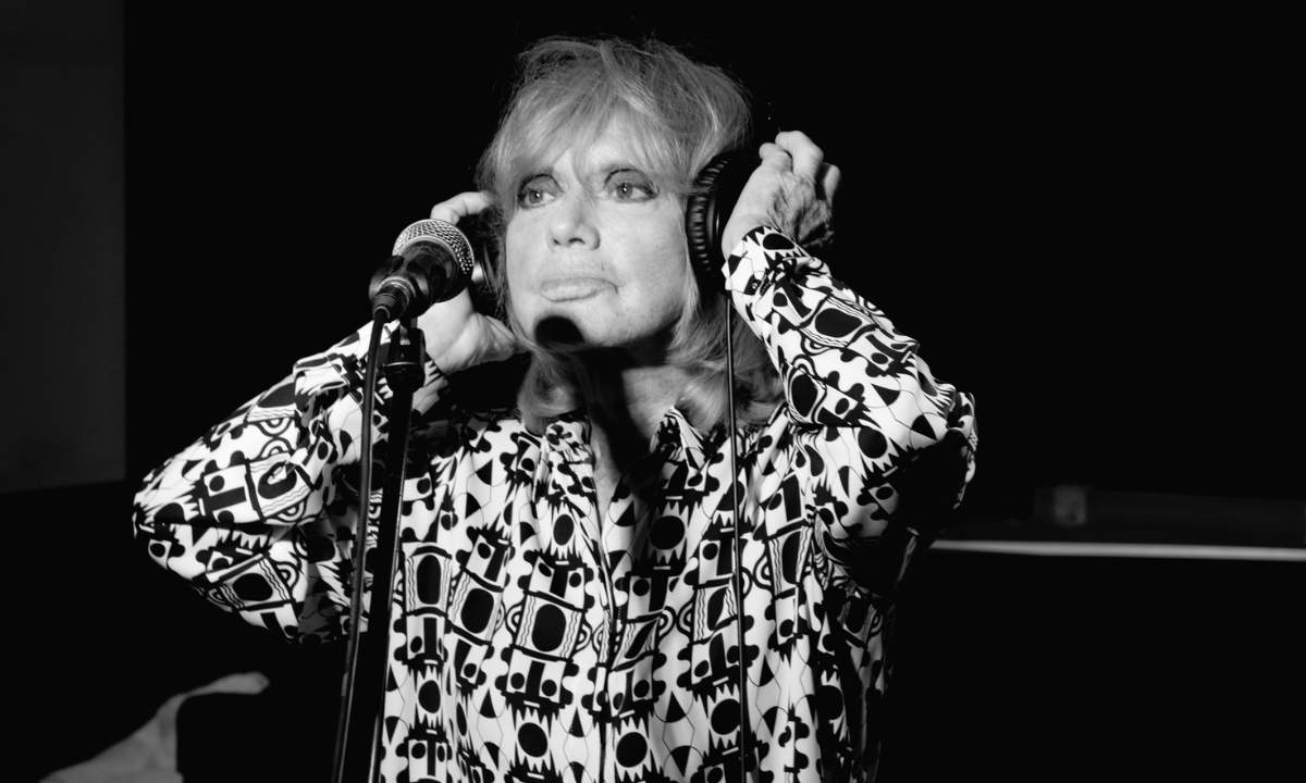 Rita Pavone in cuffia al microfono durante la registrazione di La notte è piccola