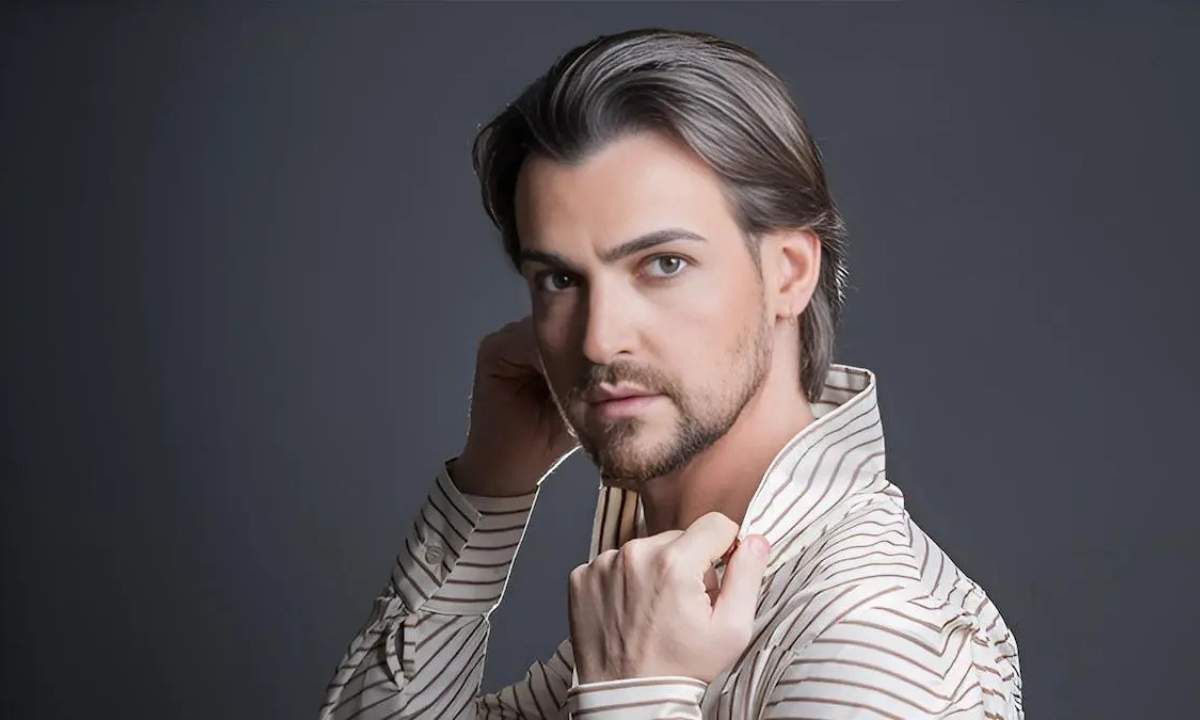 Valerio Scanu in una foto promozionale, camicia a righe e sguardo in camera su fondo grigio