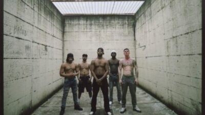 Cinque detenuti del carcere di Bollate a torso nudo in un cortile, foto del progetto 30 OP