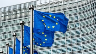 Le bandiere dell'Unione europea davanti al Berlaymont, sede della Commissione europea, per l'AI Act e le regole sulla musica generata con l'IA