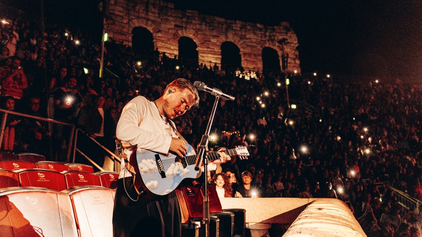 Alfa in concerto all’Arena di Verona con la chitarra, davanti al pubblico con le luci dei telefoni accese