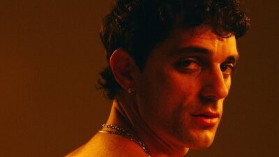 Bresh, autore del suo primo romanzo Nessuno ci insegna a cadere, in un ritratto con luce arancione