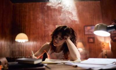 Elisa scrive a una scrivania in penombra, immagine legata al singolo Kintsugi