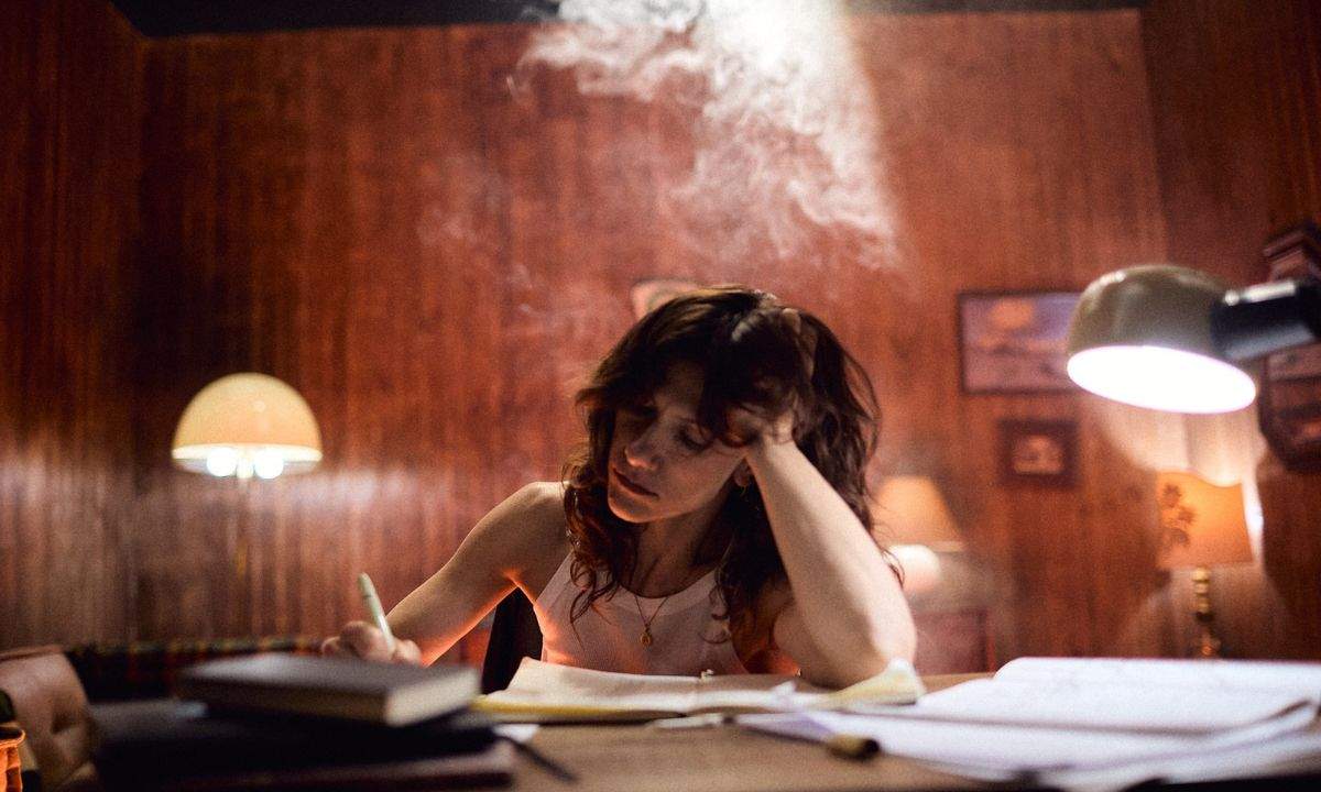 Elisa scrive a una scrivania in penombra, immagine legata al singolo Kintsugi