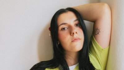 Gioia Lucia in un ritratto fotografico con maglia verde lime, immagine ufficiale per il singolo Una canzone allegra