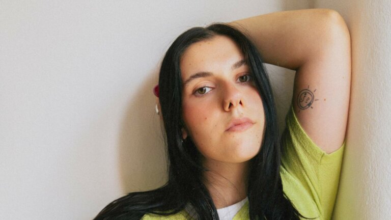 Gioia Lucia in un ritratto fotografico con maglia verde lime, immagine ufficiale per il singolo Una canzone allegra