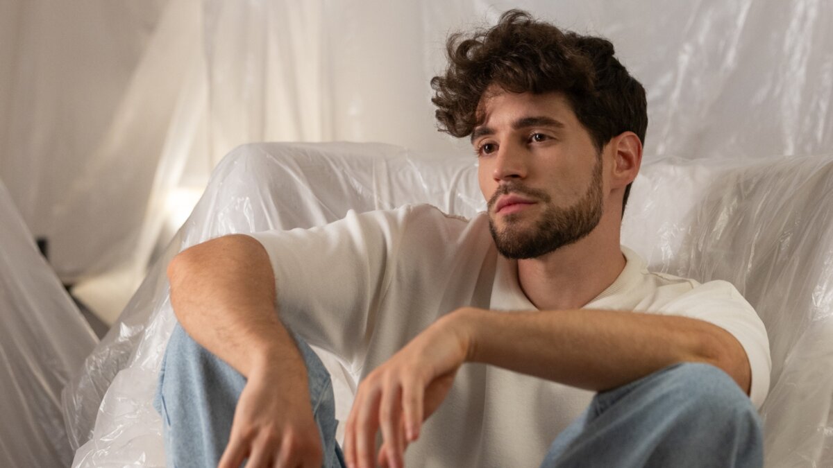 Matteo Faustini seduto su una poltrona, con maglietta chiara e jeans