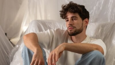Matteo Faustini seduto su una poltrona, con maglietta chiara e jeans