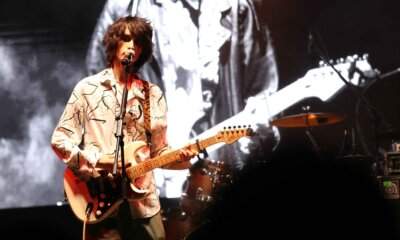 Nicola Ferrari canta al microfono con la chitarra elettrica sul palco