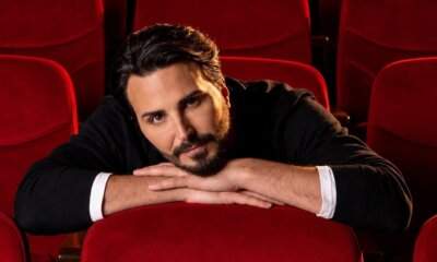 Tony Colombo appoggiato a una poltrona rossa di teatro