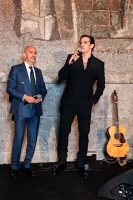 Achille Lauro con il microfono sul palco della presentazione di Casa Ragazzi Madre a Milano