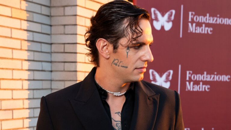 Achille Lauro davanti al backdrop di Fondazione Madre alla presentazione di Casa Ragazzi Madre a Milano