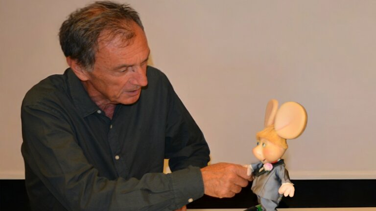 Andrea Rosi, presidente e CEO di Sony Music Italy, stringe la mano a Topo Gigio nella foto della firma con l'etichetta