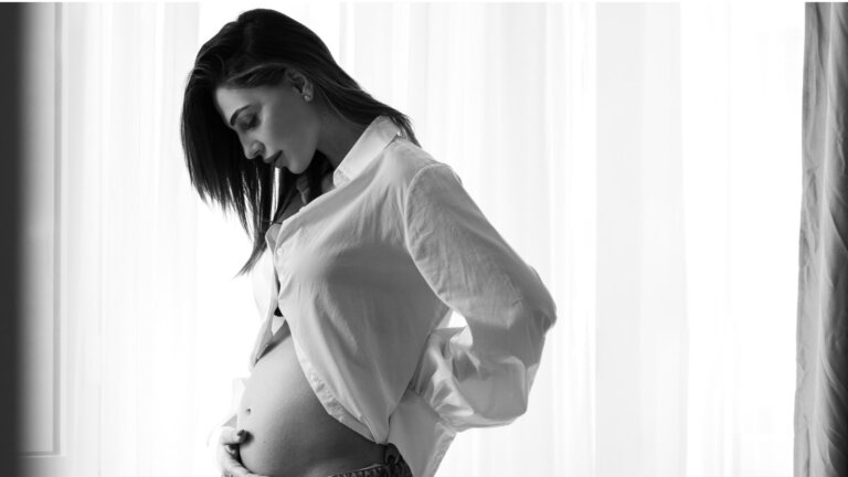 Anna Tatangelo, ospite di Verissimo con il figlio Andrea, in una foto in bianco e nero con la mano sul pancione dal suo profilo Instagram