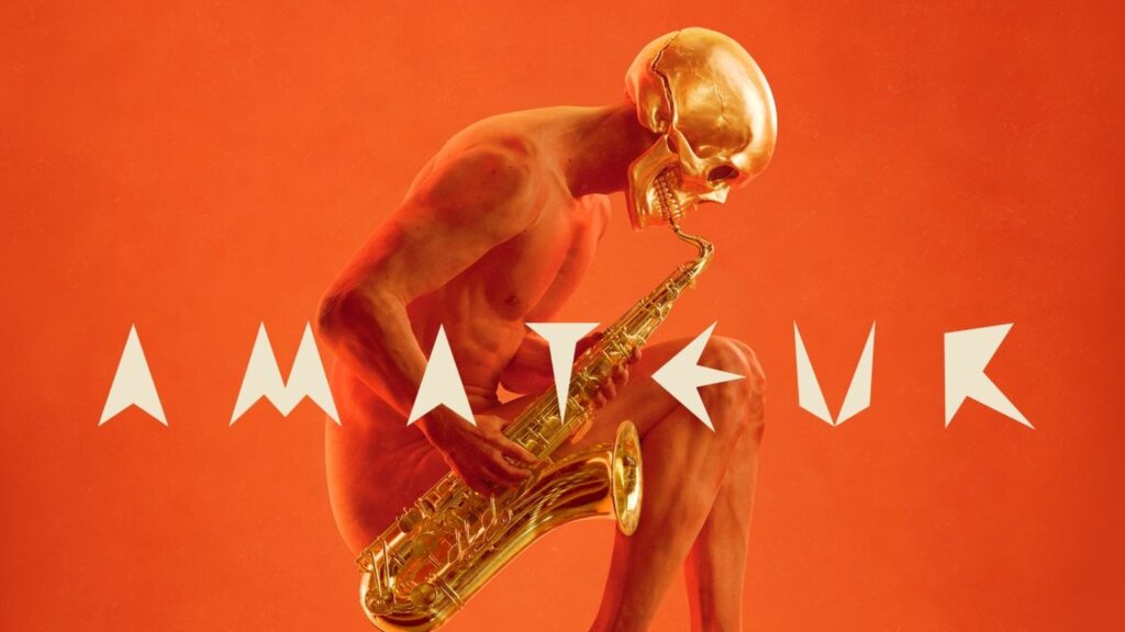 La copertina di AMATEUR di Cesare Cremonini: un corpo seduto con un teschio dorato al posto della testa suona un sassofono su sfondo arancione