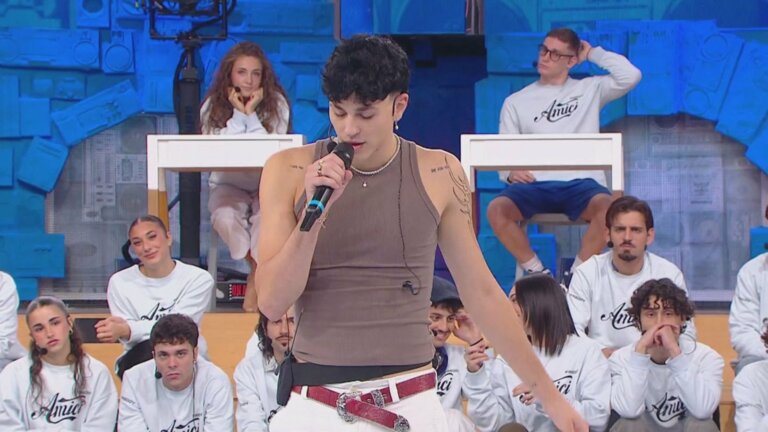 Nicolò Bassani canta Un altro ancora nella prima puntata di Amici 26, con canotta marrone e microfono