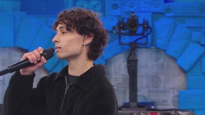 Paulo, cantante di Amici 26, con il microfono in mano durante la prima puntata