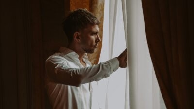 Vegas Jones affacciato a una finestra tra le tende, foto promozionale del singolo Nel dubbio