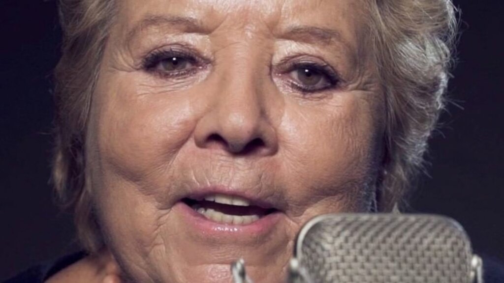 Wilma De Angelis canta al microfono in uno studio di registrazione, primo piano