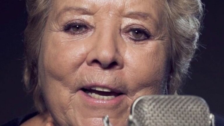 Wilma De Angelis canta al microfono in uno studio di registrazione, primo piano